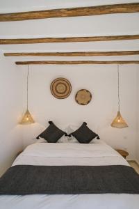 een slaapkamer met een wit bed met zwarte kussens bij Riad Rahal in Marrakesh