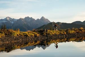 une personne à vélo à côté d'une masse d'eau dans l'établissement Hotel Alte Post, à Fieberbrunn