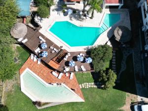 - une vue sur la piscine avec chaises longues et le complexe dans l'établissement Hotel El Condado, à Villa Carlos Paz