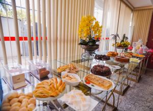 une table remplie de différents types de pain et de viennoiseries dans l'établissement Costa Atlantico Hotel, à São Luís