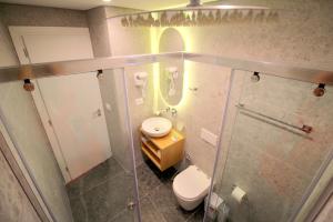 a bathroom with a toilet and a sink and a shower at Blue Eye Hotel in Ksamil