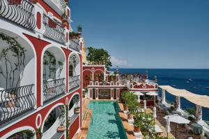 ein Gebäude mit einem Pool am Meer in der Unterkunft Le Sirenuse in Positano