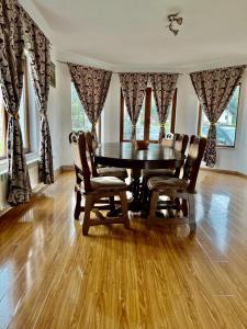 een eetkamer met een houten tafel en stoelen bij Casa Rus in Leordina