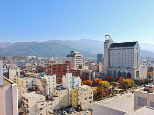 uma vista aérea de uma cidade com edifícios e montanhas em Hotel Buena Vista em Matsumoto