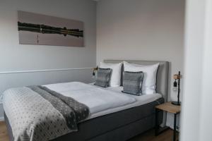 a bedroom with a bed with white sheets and pillows at Schlei Hotel in Kappeln