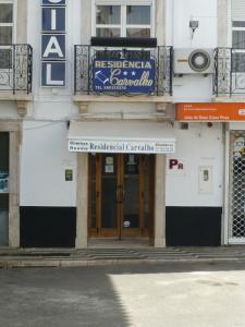 een gebouw met een bord aan de voorkant bij Residencial Carvalho in Estremoz