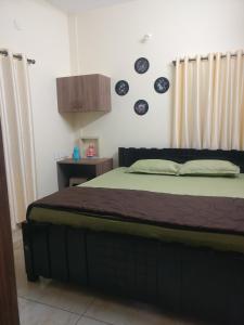 - une chambre avec un grand lit dans l'établissement SindooRa, à Mysore