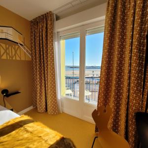 1 dormitorio con ventana y vistas al océano en Seakub hotel, en Royan