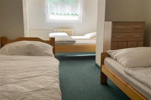 a bedroom with two beds and a dresser and a window at Chata Čeňkovka in Srní