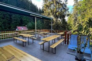 a group of tables and chairs on a patio at Chata Čeňkovka in Srní