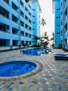 a hotel with a swimming pool in front of a building at Cowrie Shell Beach Apartments Official in Bamburi