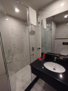 a bathroom with a sink and a glass shower at Avari Xpress Gilgit in Gilgit