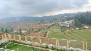 una vista de una ciudad en una colina con una valla en Glen Premium Villa By LexStays, en Ooty