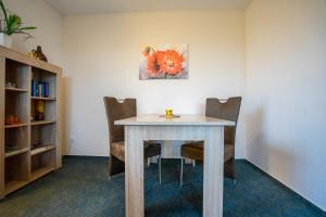 uma mesa de jantar com cadeiras e um quadro na parede em Haus Kim Wohnung 2 em Büsum