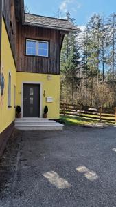 une maison jaune avec une porte sur son côté dans l'établissement Haus Waldbach, à Hallstatt