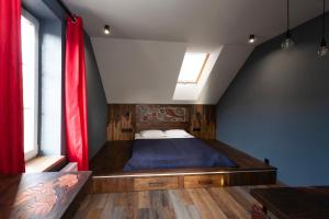 a bedroom with a bed with a red curtain at Гостьовий дім Білий пацюк in Kamianets-Podilskyi