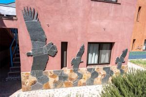 una pintura de dos pájaros al lado de un edificio en Casa de Peter, en Cafayate