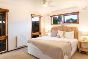 a bedroom with a large bed and two windows at Torquay Hotel/Motel in Torquay