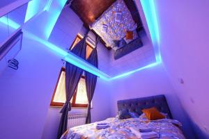 a bedroom with a bed with a blue lighting at Hedonist Spa Jacuzzi Sarajevo in Sarajevo