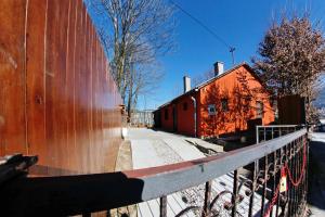 a fence next to a red wall with a building at Hedonist Spa Jacuzzi Sarajevo in Sarajevo