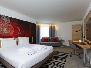 um quarto de hotel com uma cama e uma secretária em Novotel München City em Munique