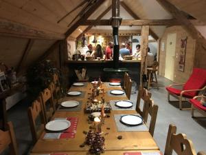 une longue table dans un restaurant avec des gens en arrière-plan dans l'établissement Chambre d'hôtes Carélie et Laponie, à Orbey