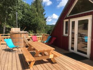 une terrasse en bois avec une table de pique-nique et des chaises dans l'établissement Chambre d'hôtes Carélie et Laponie, à Orbey