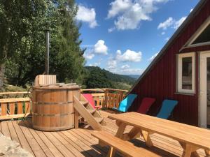 une terrasse avec une table et des chaises en bois ainsi qu'un tonneau dans l'établissement Chambre d'hôtes Carélie et Laponie, à Orbey