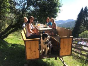 Un groupe de femmes assises à une table avec un chien dans l'établissement Chambre d'hôtes Carélie et Laponie, à Orbey