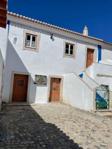 um edifício branco com duas portas e uma escada em Paço Marmòris Field em Sintra