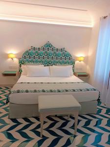 Schlafzimmer mit einem großen Bett mit blauem Kopfteil in der Unterkunft Hotel Il Gabbiano in Positano