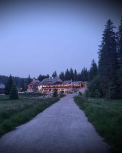 a road leading to a large house at night at Pivovar Lyer in Modrava