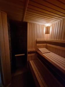 a sauna with a wooden bench in a room at Pivovar Lyer in Modrava