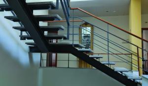 un escalier dans un bâtiment avec des balustrades bleues et oranges dans l'établissement Hotel Apartamentos Geres Ribeiro, à Gerês