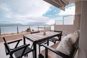 una mesa y sillas en un balcón con vistas al océano en Villa Athina, en Preveza