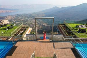 een vrouw in een rode jurk op de trap van een gebouw bij The Cliff by Zuper - Panchgani in Panchgani