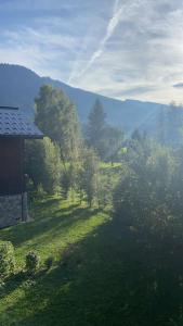 een uitzicht op een veld met bomen en een huis bij Three bedroom Apartment, Samoens, Grand Massif in Samoëns