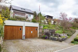 une maison avec un garage en bois avec un mur de retenue dans l'établissement Studio CHic, à Niederweningen