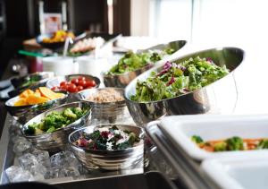 una linea a buffet con ciotole di verdure e altri prodotti alimentari di APA Hotel TKP Keikyu Kawasaki Ekimae a Kawasaki