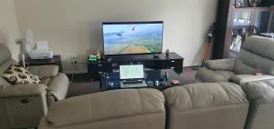 a living room with a couch and a tv at Home stay in Wyndham Vale