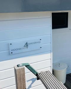 a wooden bench sitting in front of a wooden wall at Woonboot 4 Harderwijk in Harderwijk