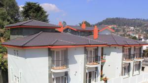 uma fila de edifícios de apartamentos brancos com telhados pretos em Two Seas Residence em Ooty