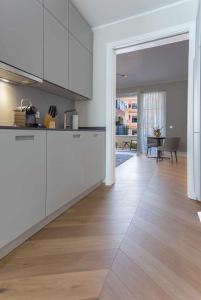 een keuken met witte kasten en een houten vloer bij Luxury Home / 2-Raum-Apartment an der Frauenkirche in Dresden