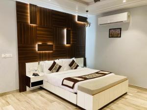 a bedroom with a white bed and a wooden wall at DESI THATH RESORT in Alwar