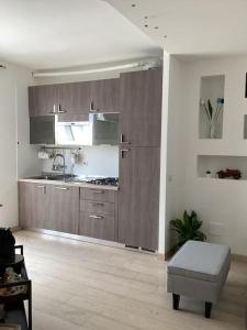 een woonkamer met een keuken met houten kasten bij Diego's Apartment - Monza Park in Biassono