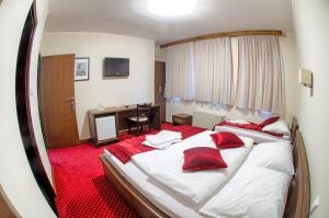 een hotelkamer met een groot bed met rode kussens bij Hotel Konak Konjic in Konjic