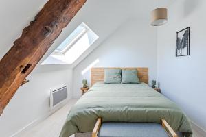 Schlafzimmer mit einem Bett mit einem Kopfteil aus Holz in der Unterkunft L’odon in Caen