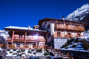 un gran edificio con una montaña cubierta de nieve en Ellex Eco Hotel, en Gressoney-la-Trinité