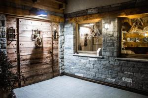 Habitación con pared de piedra y puerta de madera. en Ellex Eco Hotel, en Gressoney-la-Trinité