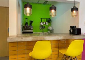 a kitchen with yellow chairs and a green wall at Estancias VIVE MX wtc in Mexico City